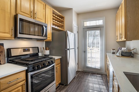 a kitchen with wood cabinets and stainless steel appliances and a refrigerator