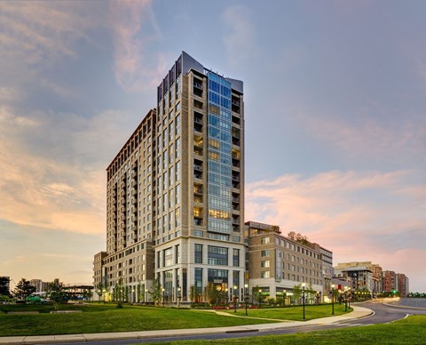 A modern multi-story building with a glass facade is the main focus of the image.