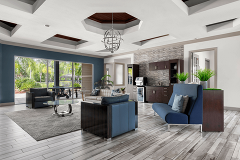 A modern living room with a dark blue sofa and a glass coffee table.