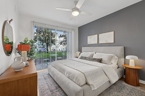 A bedroom with a large bed and a ceiling fan.
