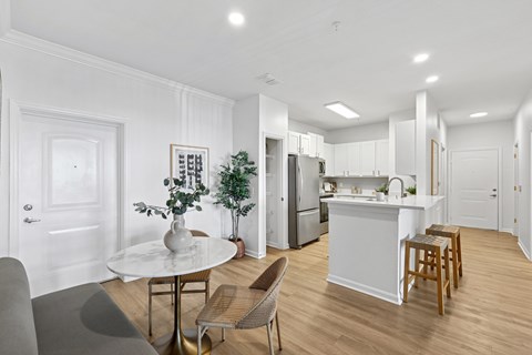 A white kitchen with a table and chairs.