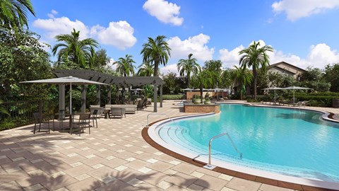 A large outdoor swimming pool surrounded by a patio and palm trees.