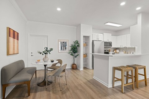 A modern kitchen with a dining table and chairs.