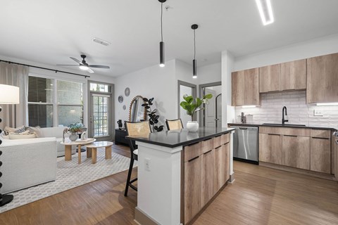A modern kitchen with wooden cabinets and a black countertop.