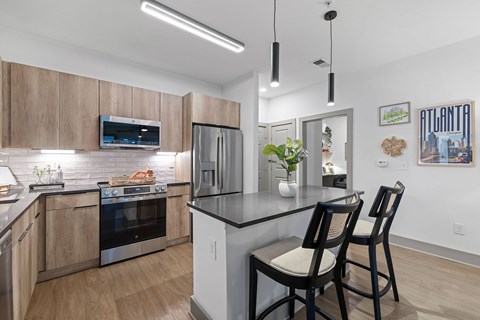 A modern kitchen with a black countertop and stainless steel appliances.