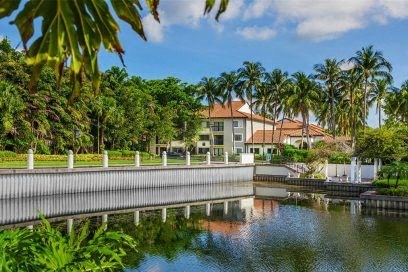 a large building with palm trees near a body of water