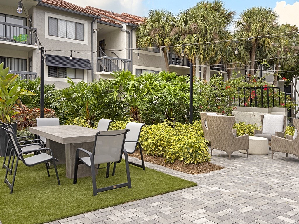 A patio with a table and chairs in front of a building.
