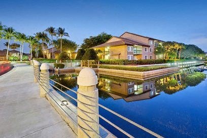 a house is reflected in the water with a dock
