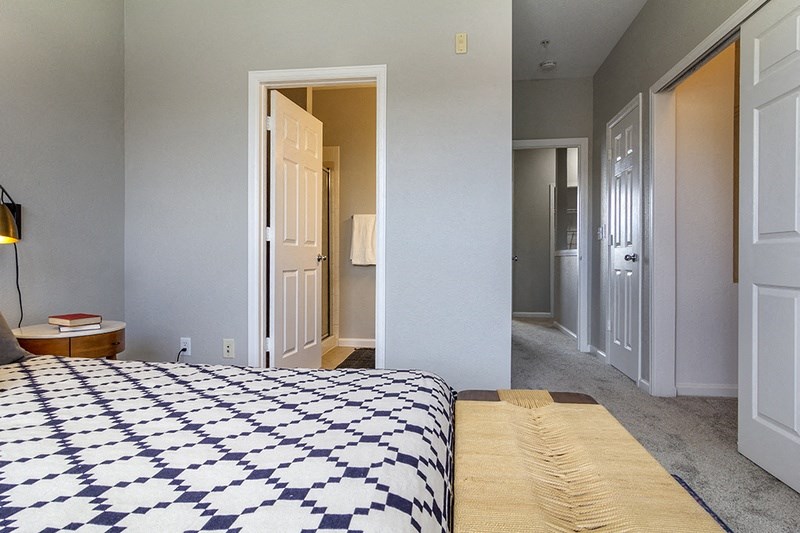 a bedroom with a bed and a hallway with a closet