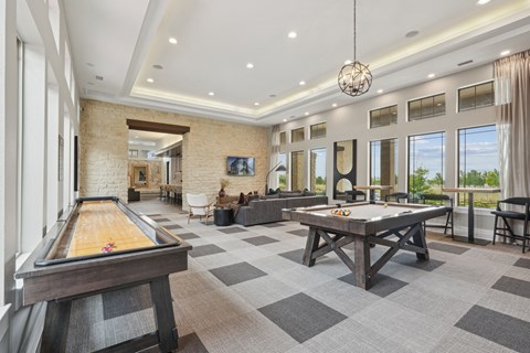 a game room with a shuffleboard table and a pool table