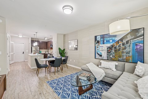 A living room with a grey couch, a coffee table, and a painting on the wall.