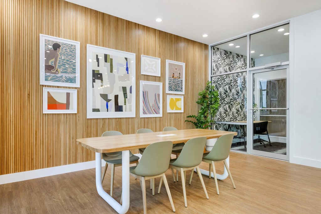 a dining room with a table and chairs and pictures on the wall