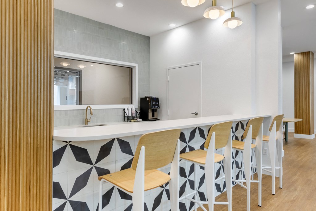 a kitchen with bar stools and a mirror in a 555 waverly unit