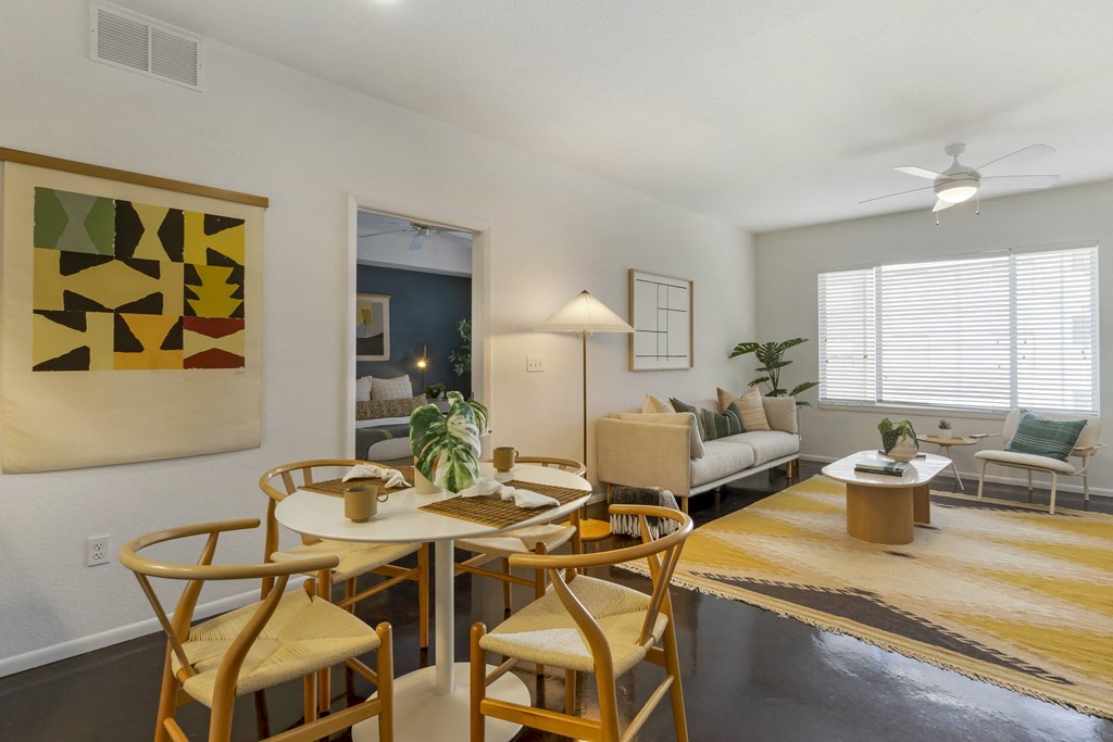 the living room and dining area with a table and chairs