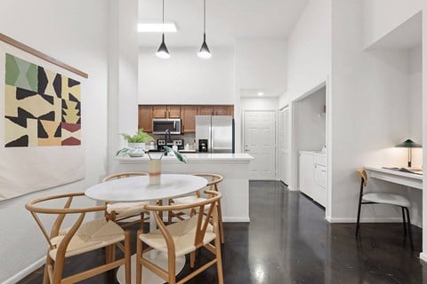 A dining room with a white table and chairs.