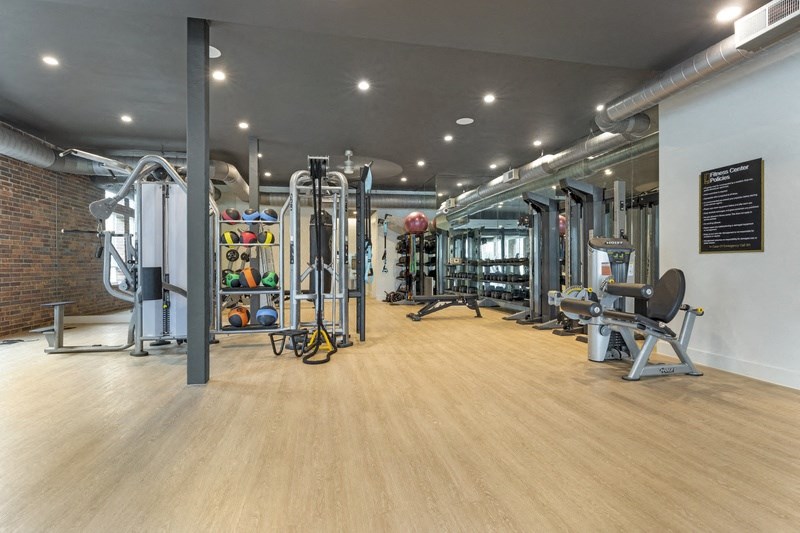 a spacious fitness room with weights and other exercise equipment