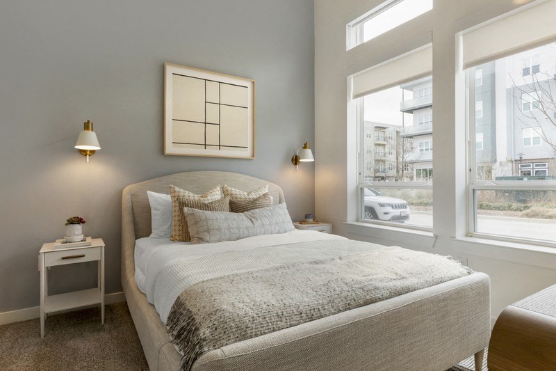 a bedroom with a bed and two windows