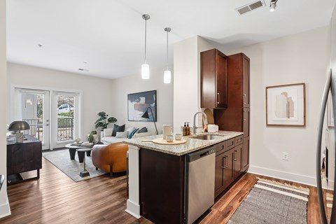 A kitchen with a black counter top and brown cabinets.