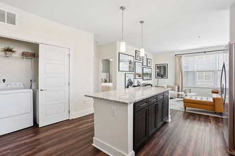 A kitchen with a white counter top and black cabinets.