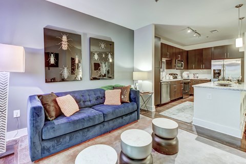 a living room with a blue couch and a kitchen