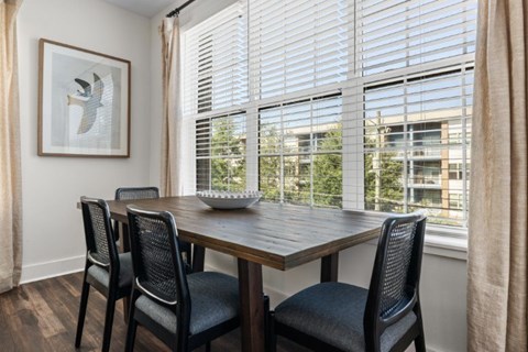 A dining room with a wooden table and chairs.