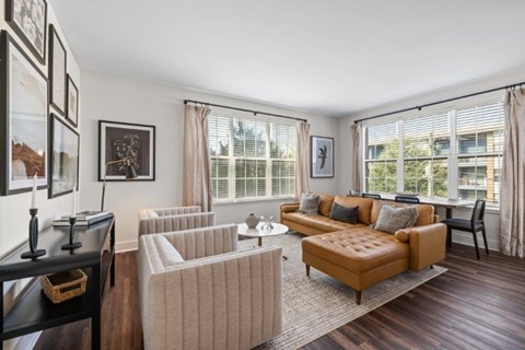 A living room with a brown sofa and a white chair.