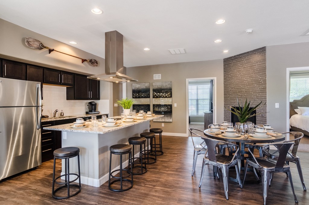 an open kitchen and dining room with a large island and stainless steel appliances