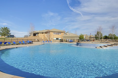 A large swimming pool with a building in the background.