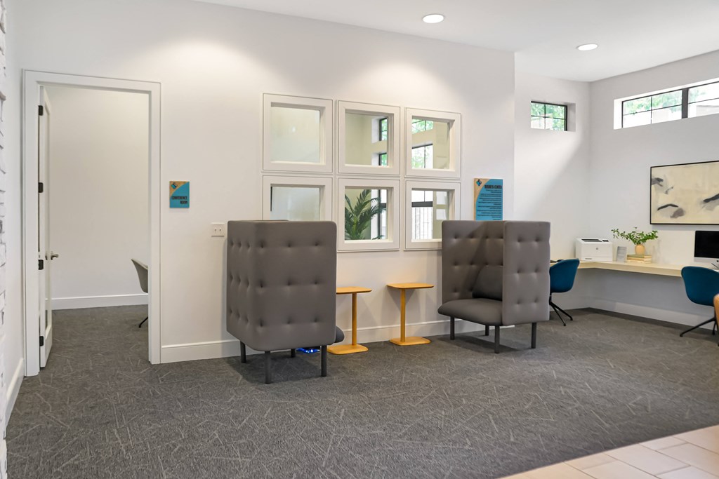 a waiting room with two chairs and a table in front of a window