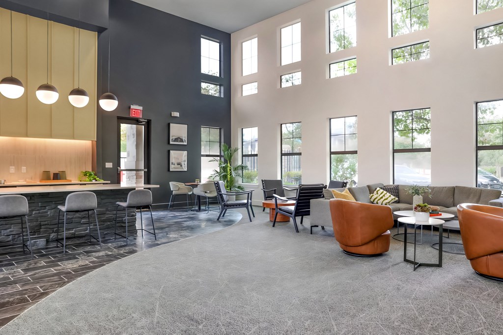 a lobby with couches tables and chairs and large windows
