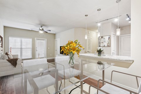 a living room and dining room with a table and chairs