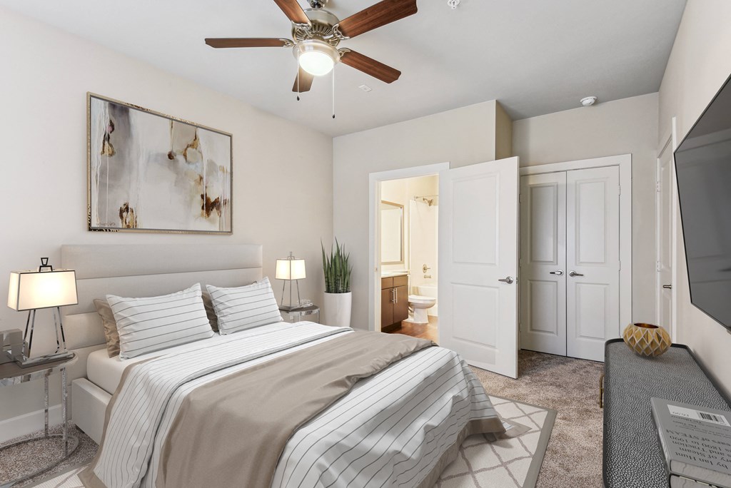 a bedroom with a large bed and a ceiling fan