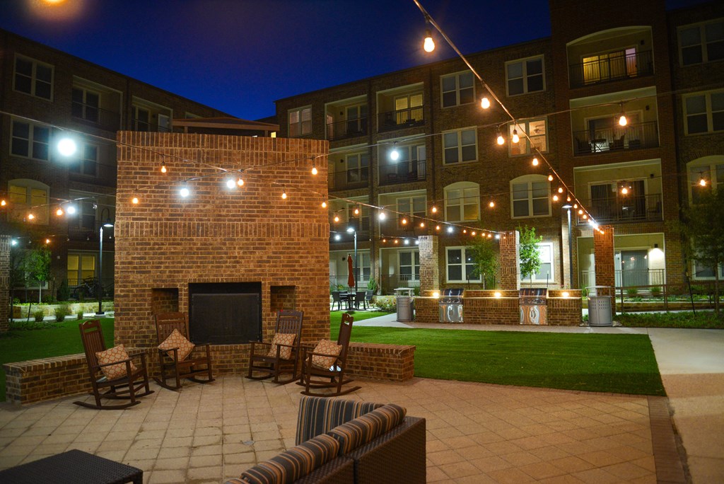 the courtyard at night with chairs and a fireplace