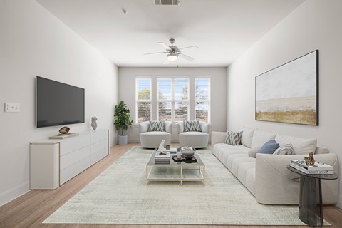 A living room with a large couch, a television, and a painting on the wall.
