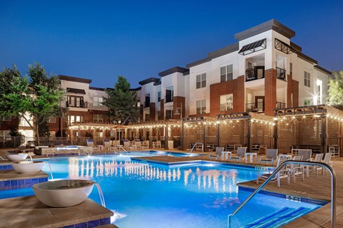 A large swimming pool with a waterfall in the middle of it.