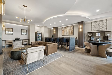 A modern living room with a black coffee table and a large painting on the wall.