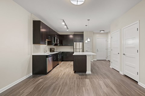 A kitchen with black cabinets and a white island.