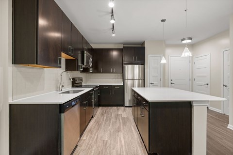 A modern kitchen with dark brown cabinets and a white countertop.