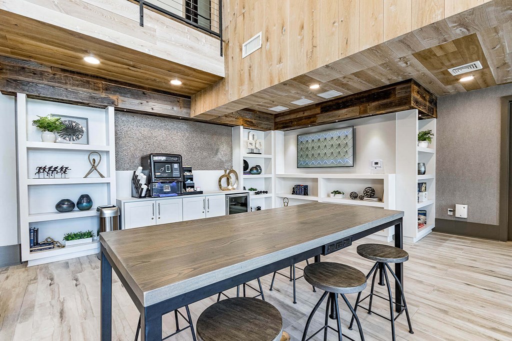 a kitchen with a long wooden table and three stools