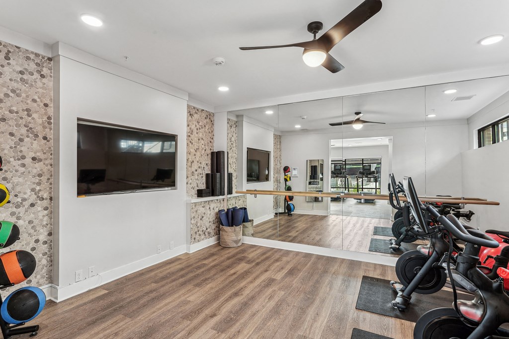 a home gym with bikes and a tv on the wall