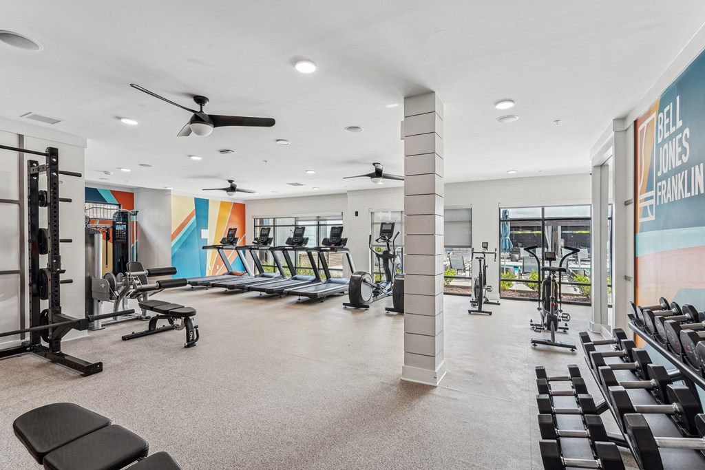 a gym with treadmills and other exercise equipment in a building with windows