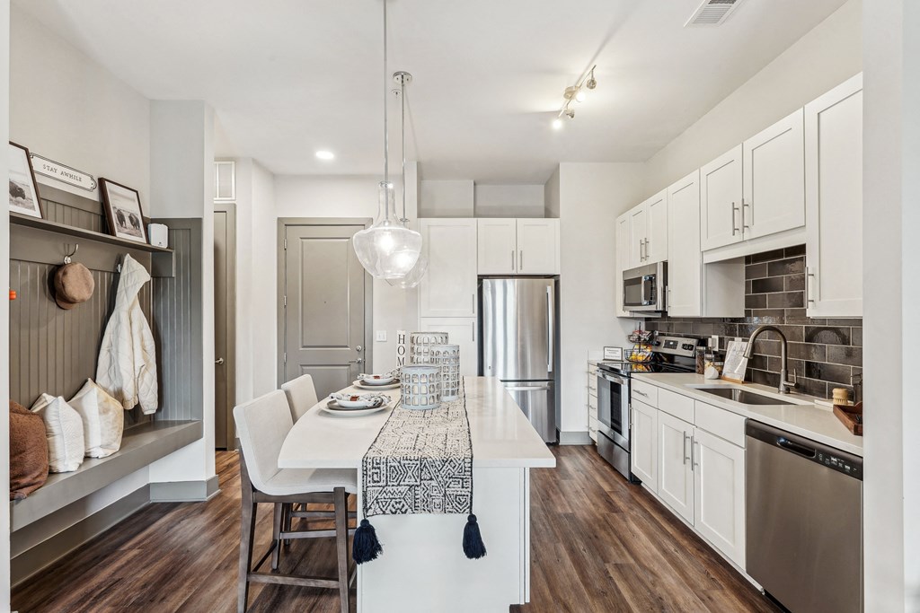 an open kitchen and dining area with a white table and chairs