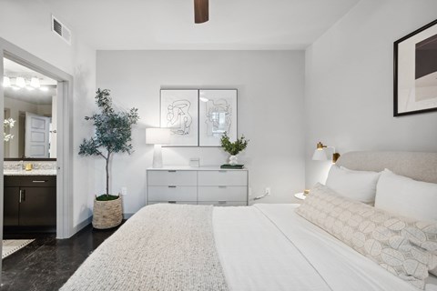 a bedroom with a white bed and a white dresser