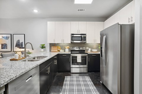 an apartment kitchen with stainless steel appliances and granite counter tops