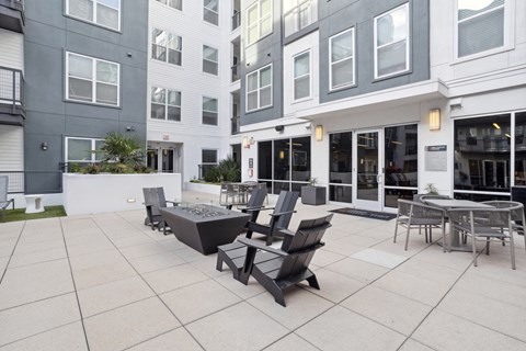 a patio with chairs and tables outside of a building