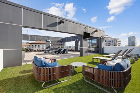 a roof top patio with couches and tables and chairs