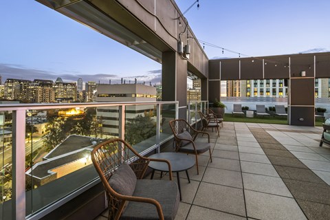 a terrace with chairs and tables overlooking a city at night