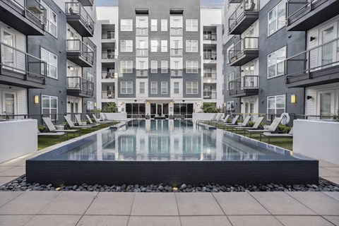an apartment swimming pool in front of an apartment building