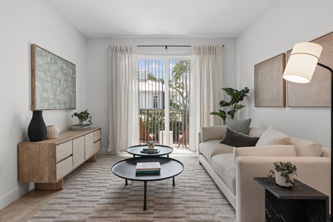 A living room with a white couch, a coffee table, and a painting on the wall.