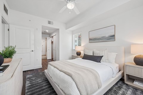 A bedroom with a large bed and a ceiling fan.